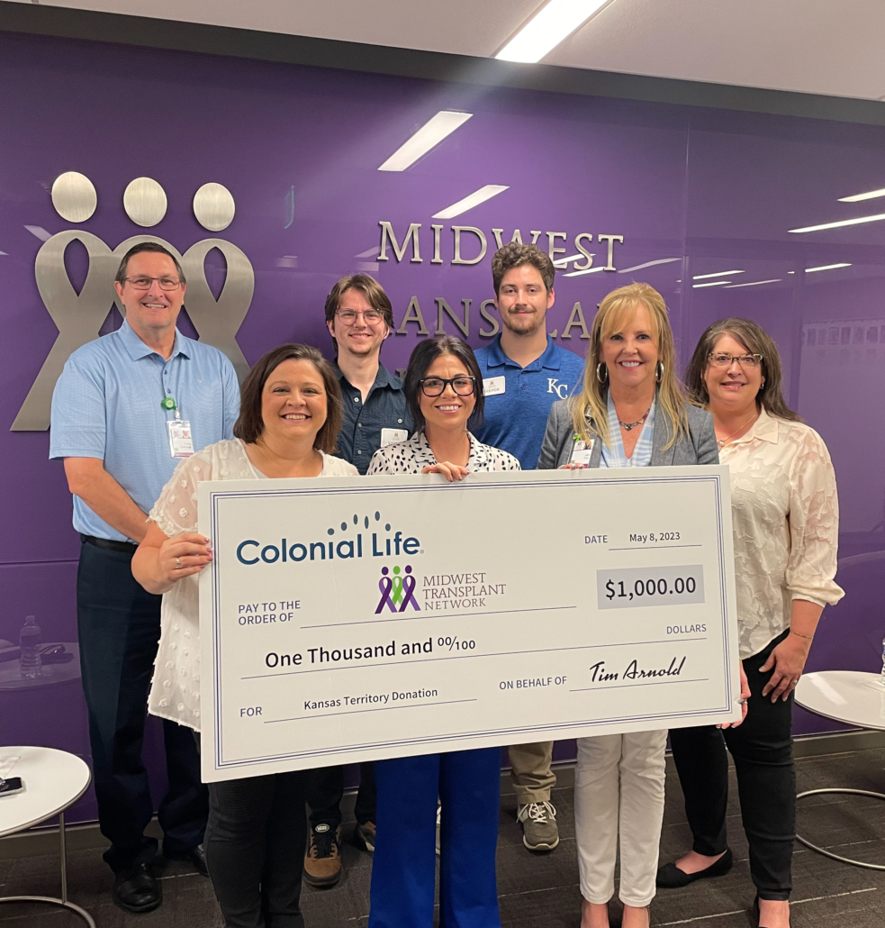 MTN staff holding a large check from Colonial Life