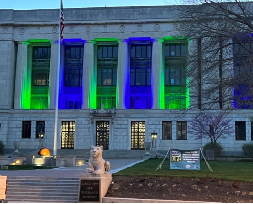 Photo of the Kansas City Life Insurance building lit up blue and green.