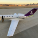 Sunset photo of the MTN airplane at the KC downtown airport with the skyline behind it.