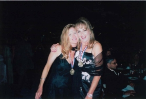 Two people posing for a photo with medals