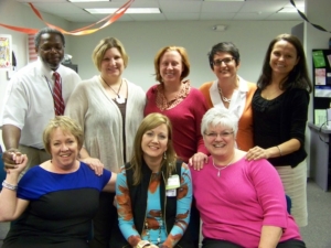 eight people in an office posing for a photo