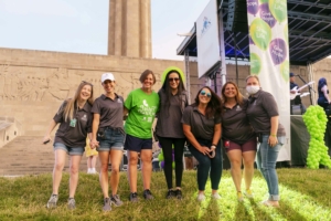 people posing for a photo outside next to a stage