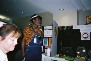 a person standing and a person sitting in front of tables