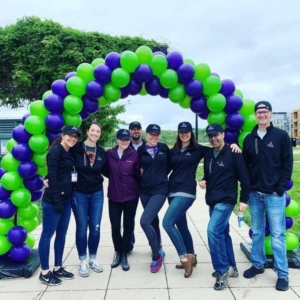 people posing in front of a balloon arch