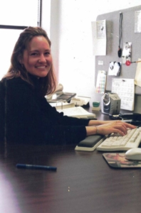 a person sitting at a desk using a keyboard and smiling