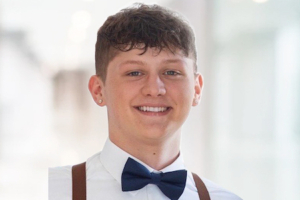 A headshot of donor hero Drew Hedrick in white shirt, black bow tie and suspenders.