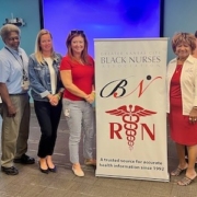 people next to a poster for Greater Kansas City Black Nurses Association