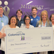 MTN staff holding a large check from Colonial Life