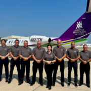 Pilots standing in formation in front of a plane owned by Midwest Transplant Network.