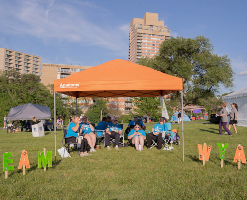 people sitting on chairs under a tent