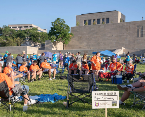 people sitting in chairs with a building in the background