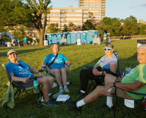 four people sitting in chairs on a field