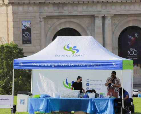 A blue and white tent that says We change lives by saving sight