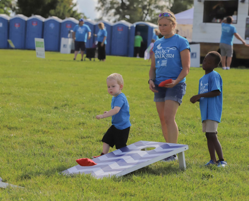 Kids and adults playing cornhole