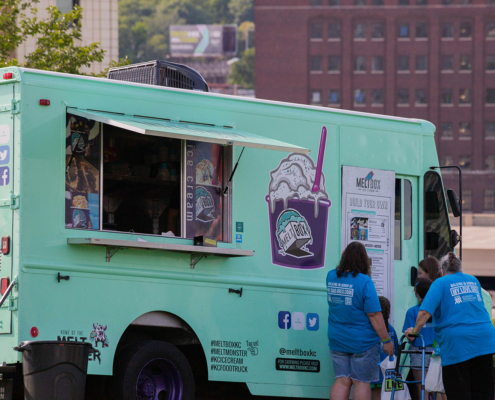 People standing next to an ice cream truck outside