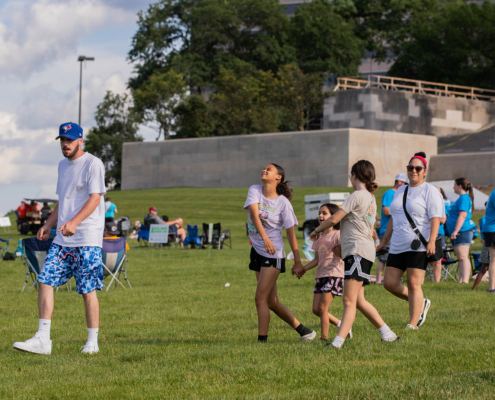 People walking on a grass field at an outdoor event