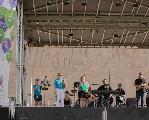 A band and people on an outdoor stage