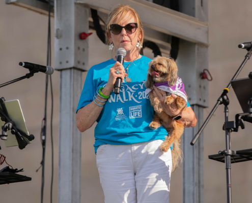 a person on stage holding a microphone and a dog