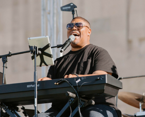 a person playing the piano and singing into a microphone