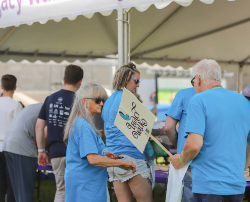 people standing next to a tent at an outdoor event