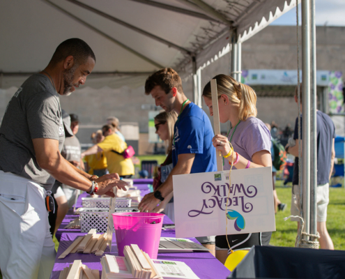 people standing around a table under a tent outside