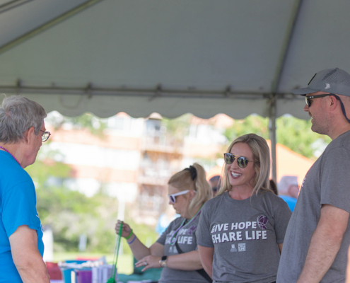 people standing around a table under a tent outside