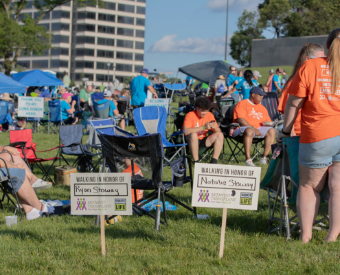 two donor signs on a grass field with people in the background