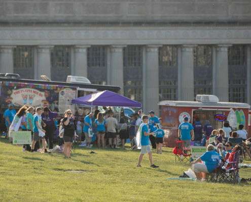 people on a grass field with food trucks in the background