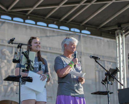 two people on stage and one is holding a microphone