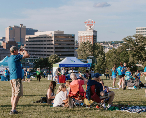 people sitting on chairs and standing at an outside event