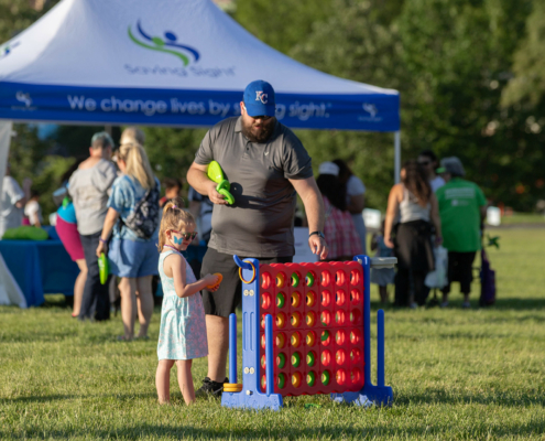 a person and a child playing outdoor connect four