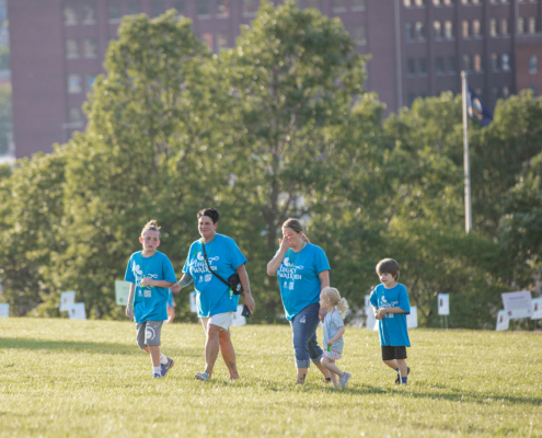 5 adults and children walking across a field