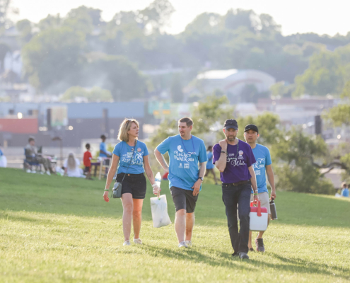 4 people walking across a field