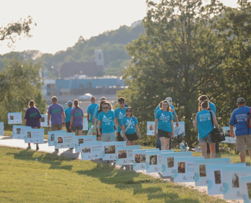 People walking along a path with signs along the edge of the path