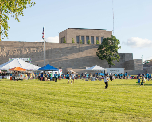 wide photo of people on a field with tents