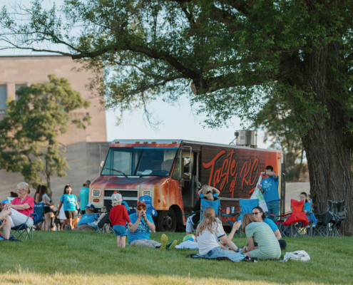 people on a field next to a food truck