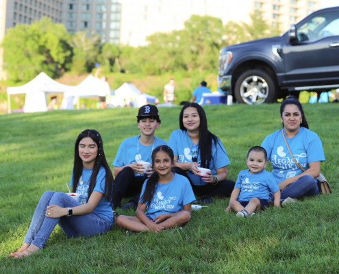 People posing for a photo while sitting on a grass field