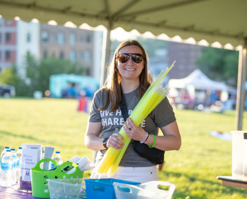 A person holding glow sticks standing under a tent