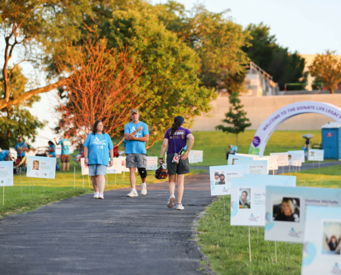 people walking on a path with posters of donors along the path