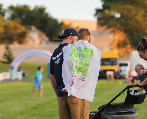 Man holding a child on a grass field