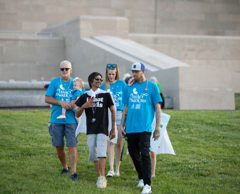 People wearing Legacy Walk shirts walking on a grass field