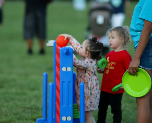 Kids playing connect four in a field